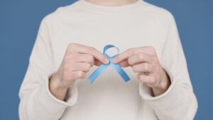 Person holding a blue ribbon | charity premises